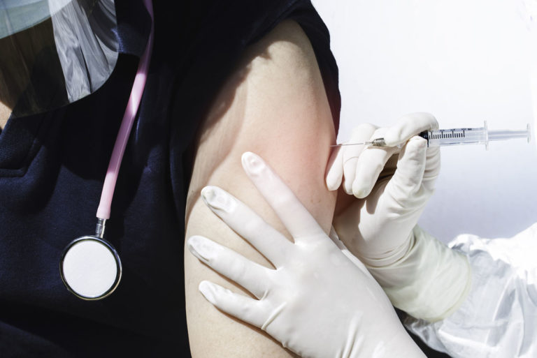 nurse receiving covid-19 vaccine
