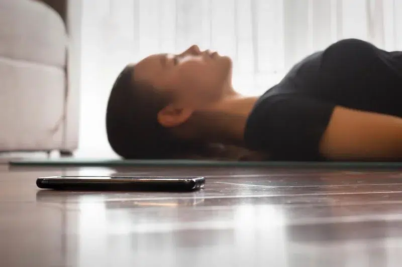 nurse lying on floor listening to a guided meditation