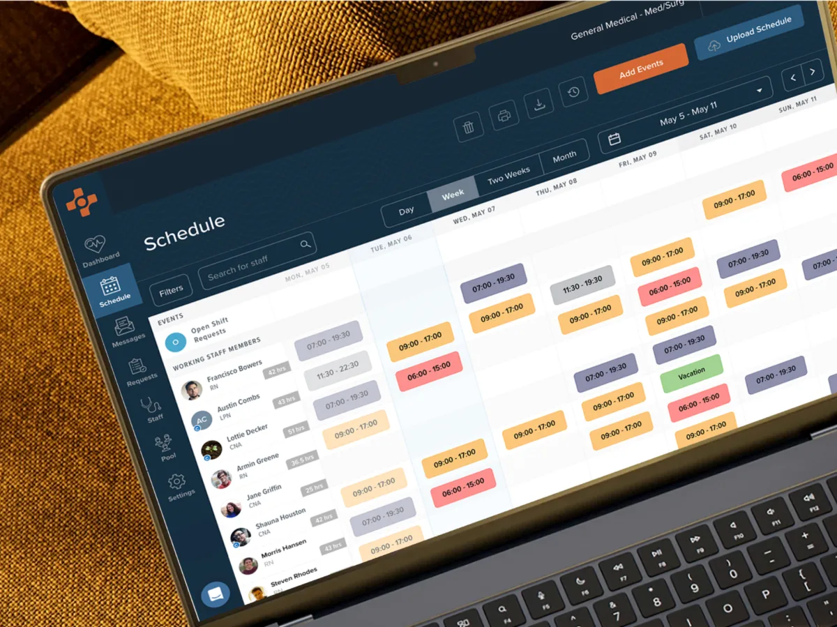 A laptop screen displays a scheduling application with a weekly calendar view, showing color-coded shifts assigned to various users.