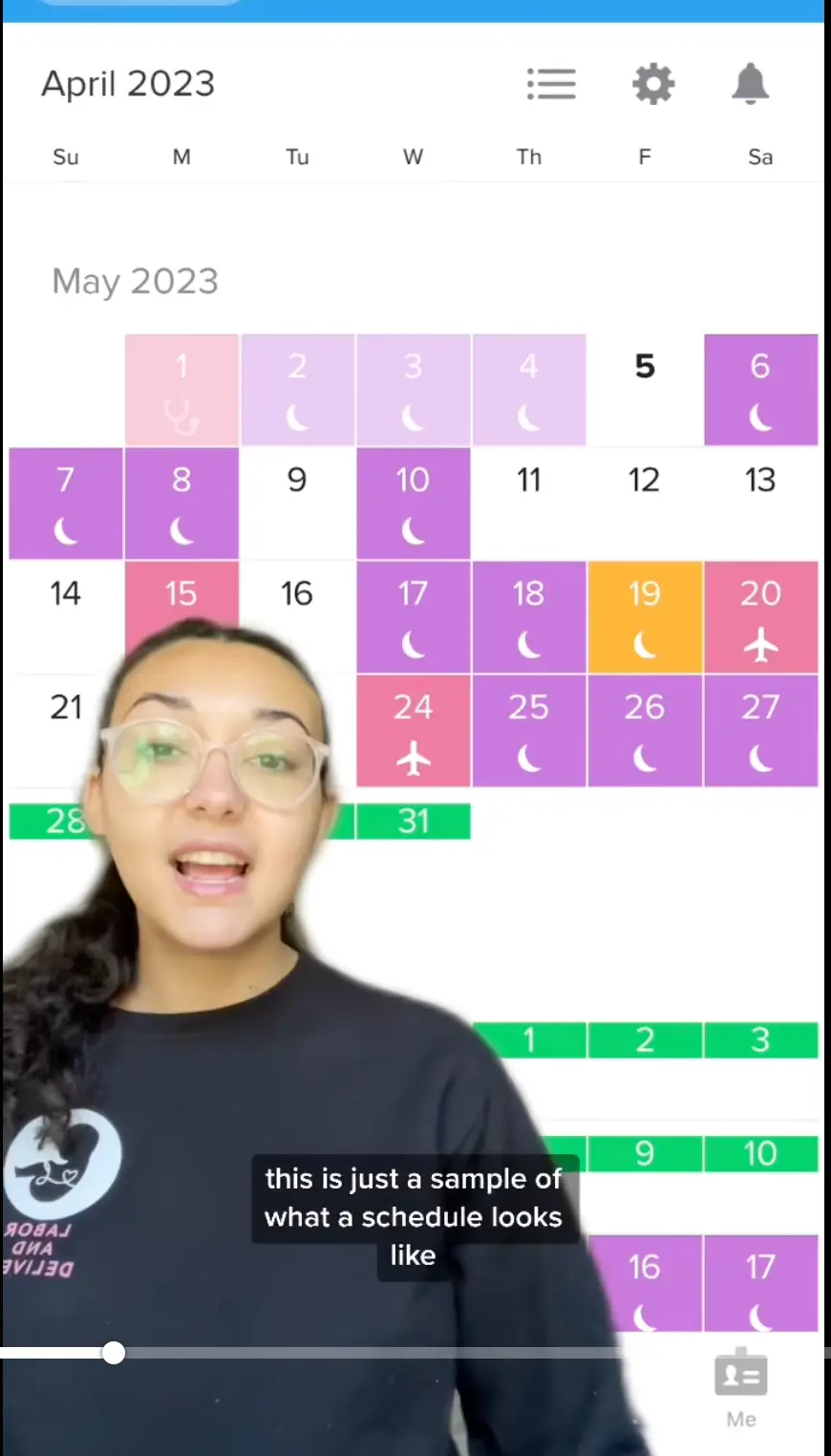 A woman with glasses stands in front of a colorful digital calendar for May 2023, explaining it. Subtitles read: this is just a sample of what a schedule looks like.